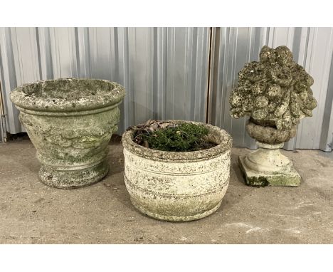 Two weathered concrete garden planters along with a finial in the form of a fruit basket 