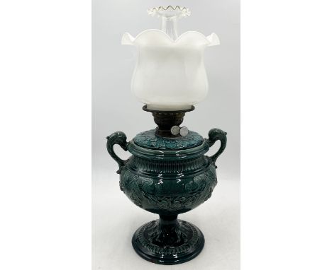 A Victorian oil lamp on ceramic urn base with stylised dolphin handles and opaque shade - indistinct mark to base