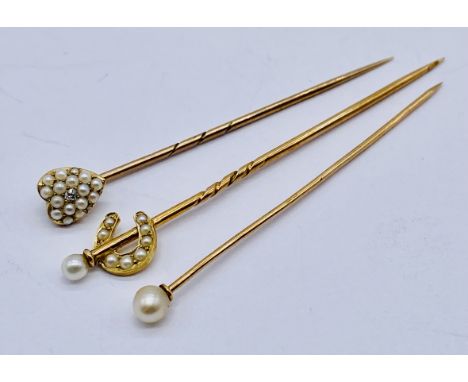 Three unmarked gold tie/stock pins including a heart shaped pin set with a diamond and seed pearls