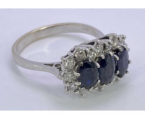 18CT WHITE GOLD DIAMOND &amp; SAPPHIRE CLUSTER RING - having three faceted oval blue central stones, 6 x 4mm, surrounded by 1