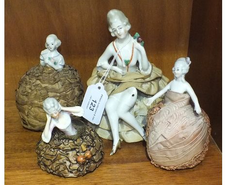 A collection of twenty-eight ceramic lady pin cushions/tea cosy holders. 