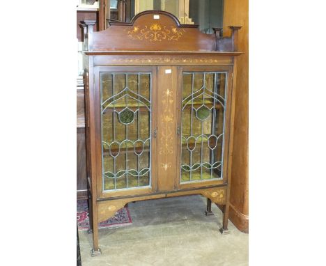 A mahogany display cabinet in the Art Nouveau taste, with stylised inlaid pattern of boxwood and mother of pearl flowers and 