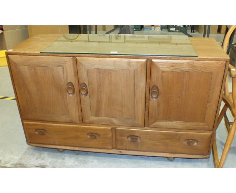 An Ercol ash 'Windsor' sideboard, the rectangular top above three cupboard doors and two drawers, on casters, (interior cutle