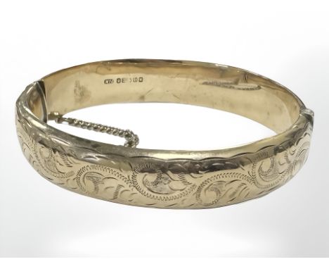 A 9ct yellow gold bangle with engraved decoration, diameter 60 mm x 57 mm internal. CONDITION REPORT: 17.8g. Hollow bangle wi