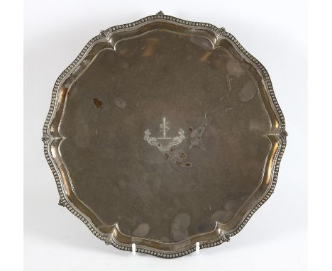 George III silver salver with shaped and beaded border on claw and ball feet, the center with family crest and motto, probabl