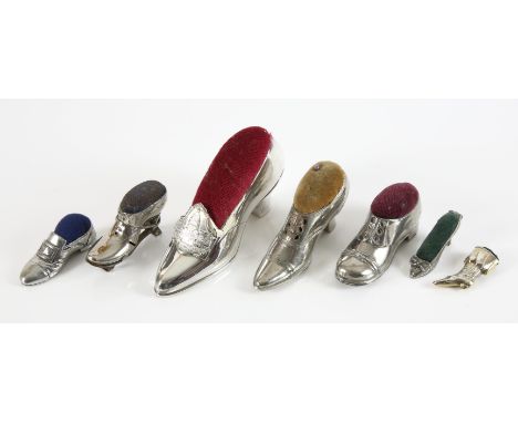 Seven silver plated and white metal novelty shoe pin cushions, including one with roller skate ( lacking wheels )