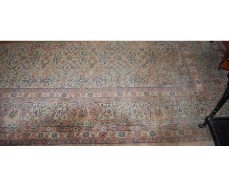 A large Persian cream ground woollen Tabriz carpet, having an all over floral stylised trailing ground, 390 x 310cm