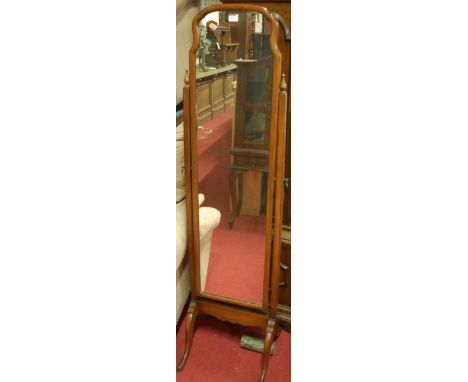 An early 20th century walnut cheval mirror, having a shaped top