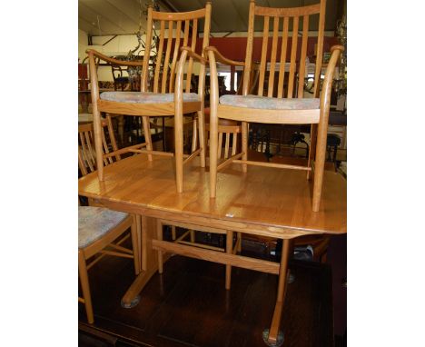 A contemporary Ercol blond elm dining suite, comprising extending dining table with pull-out action and single fold-out leaf,