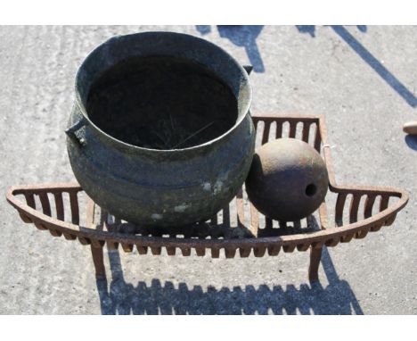 A cast metal fire grate, a cauldron and a ball. The fire grate, L73cm, the cauldron, H27cmAll items in this auction are sold 
