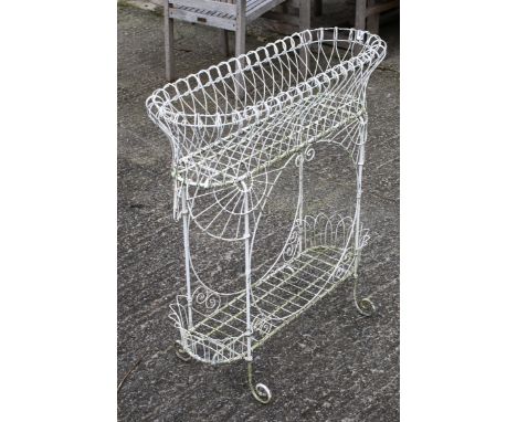 A wire planter stand in white. With scroll rim and feet, H83cm x W80cm x D29cm. All items in this auction are sold as seen, W