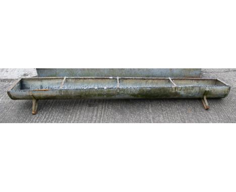 A galvanised trough. Of rounded form, on raised supports, H33cm x W275cm x D34cm (excluding legs)All items in this auction ar