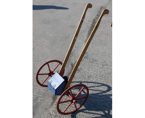 A vintage seed drill. Constructed of wood with red painted iron wheels. H104cmAll items in this auction are sold as seen, We 