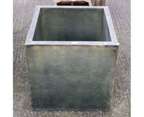 A square fibreglass garden planter. H60cm x W60cm x D60cmAll items in this auction are sold as seen, We are unable to provide