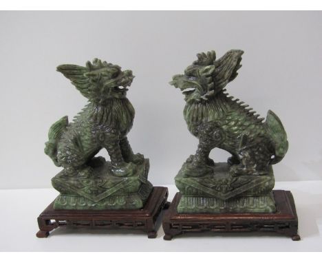 ORIENTAL CARVINGS, a pair of carved jade temple dogs on carved rectangular hardwood stand, 23cm overall height 