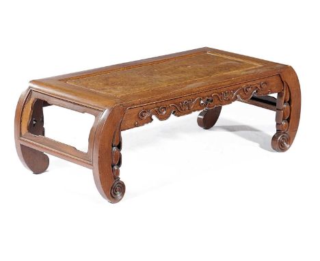 A CHINESE PADOUK KANG TABLE LATE 19TH CENTURYthe top with a burr panel, above a frieze carved with bats and curved scroll end