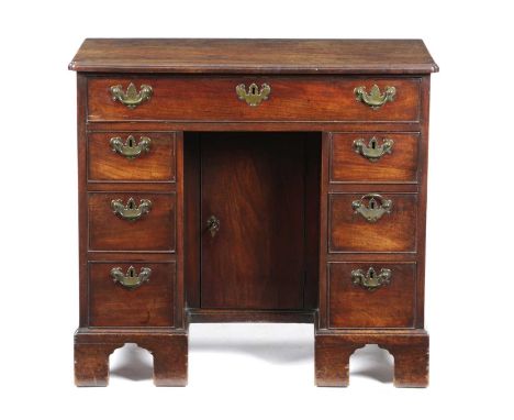 AN EARLY GEORGE III MAHOGANY KNEEHOLE DESKC.1760the top with a caddy moulding and re-entrant front corners, above seven drawe