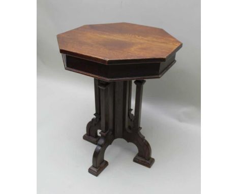 A 19th century oak lamp table of Gothic design, octagonal top, on cluster supports and four arched feet, the top 55cm