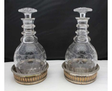 A pair of early 19th century Georgian design triple ring neck decanters, with engraved floral decoration, star cut mushroom s