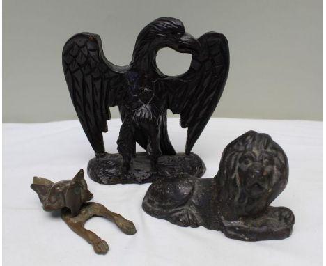 A 19th century cast iron lion, 9cm high, together with a carved wood spread eagle, and a brass fox door knocker