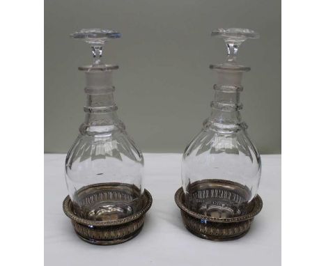 A pair of early 19th century Georgian design triple ring decanters facet cut with hexagonal stoppers, together with a pair of