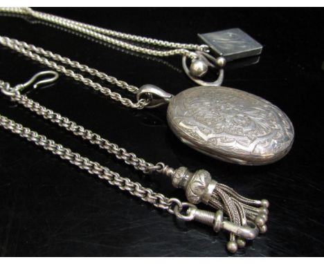 A Victorian engraved oval locket hung on silver chain, a silver stamp case on chain and a Victorian watch chain with tasselle