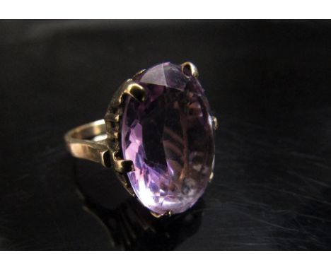 A gold ring set with a large oval amethyst, 20mm x 14mm. Size K, 8g 