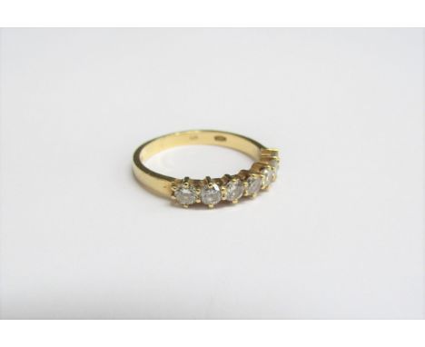 An 18ct gold ring set with a line of seven brilliant cut diamonds 0.60ct approx total. Size J/K, 2.2g 