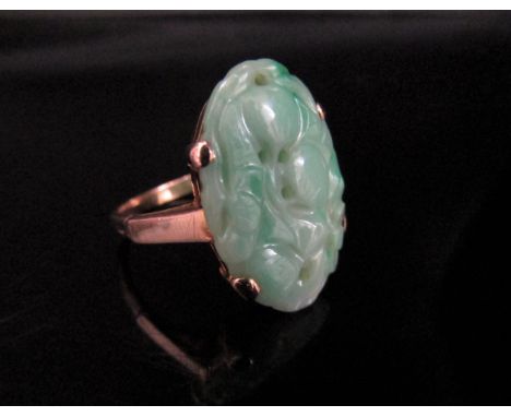 A gold ring with a pierced carved jade oval in claw mount, stamped 9ct. Size O, 4.3g 