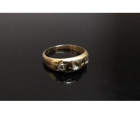 A gold ring set with three old cut diamonds in star settings, unmarked. Size K, 3.2g 