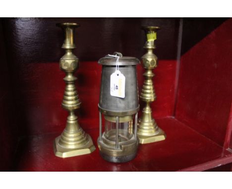 A pair of brass candlesticks and a miners lamp