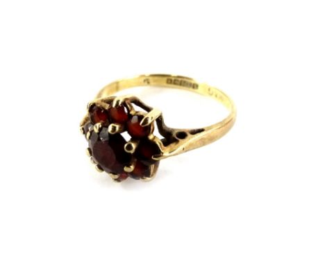 A 9ct gold floral cluster ring, set with garnets, in raised basket design, ring size K, 2g all in, in C H Berry Limited of Hi