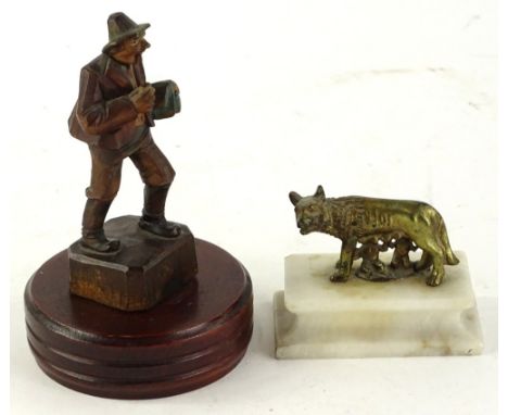 A Grand Tour type gilt metal sculpture of Romulus and Remus on a white marble base and a Black Forest carved figure of a gent