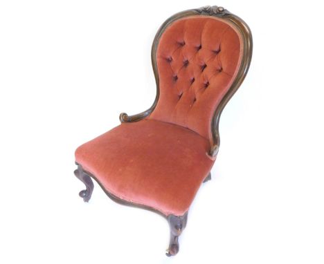 A Victorian walnut nursing chair, the button back, a padded seat on scroll carved legs with ceramic castors.