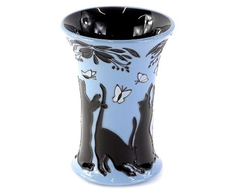 A Moorcroft ceramic vase, decorated in black with cats, butterflies, flowers, etc on a powder blue ground, original retail st