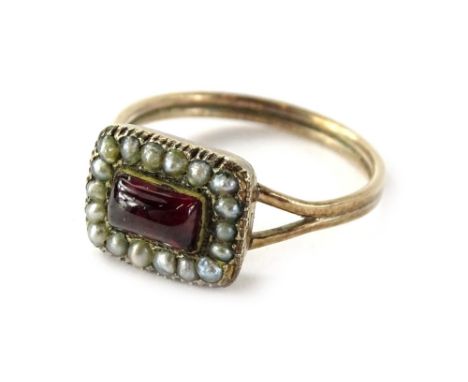 A Victorian dress ring, of rectangular form set with central cut ruby, surrounded by seed pearls, with v shaped shoulders and