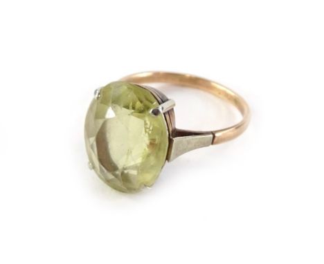 A 9ct gold dress ring, with oval facetted pale yellow central stone, in four claw silver setting, with silvered shoulders, ri