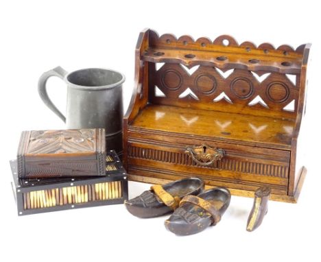 A collection of items, to include a pipe rack with drawer, a pair of treen clogs, a carved treen boot decorated with a hand, 