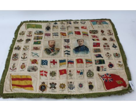 Collection of First World War silk military badges, portraits and flag stitched to a cloth backing with green fringe, 59cm sq