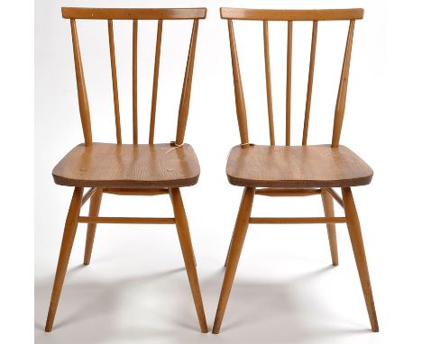 Ercol: two elm seated spindle back chairs, raised on turn tapering legs joined by stretchers.