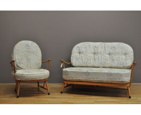 Ercol: a light stained spindle back sofa and easy chair, upholstered in floral patterned material. (2)