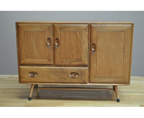 Ercol: an elm sideboard fitted three cupboard doors and one drawer, 114cms (45in.) wide. 