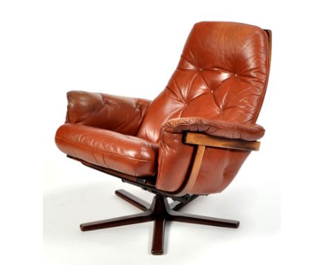 A Danish style leather and stained teak reclining armchair, with button back seat and arm cushions in brown leather.