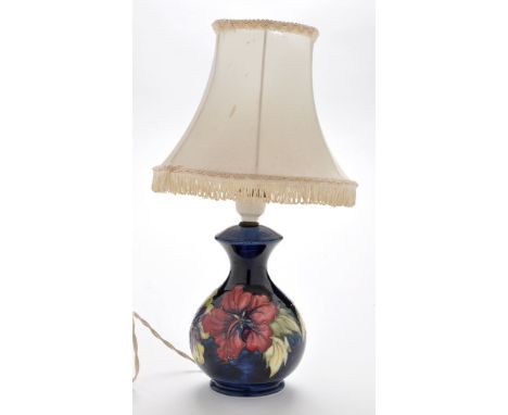 William Moorcroft: a hibiscus pattern table lamp, with dark blue ground of baluster form, impressed mark, 17cms (6 3/4in.) hi