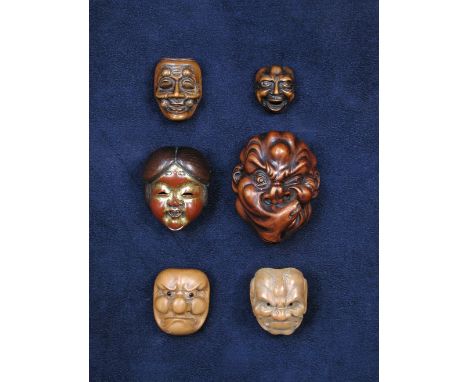 A lacquered mask netsuke of Okame, signed Shumin, her laughing red ground face once gilt, her parted hair from the brown wood