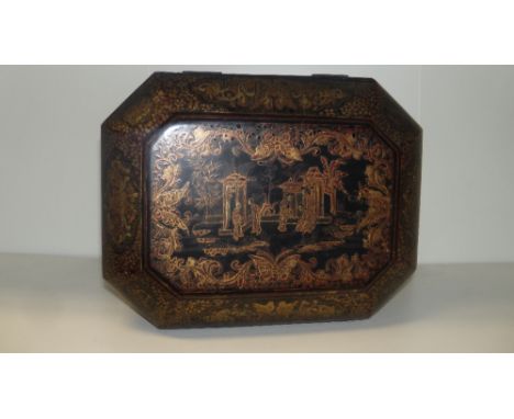 A 19th century lacquer tea caddy, the canted rectangular hinged lid gilt with figures by a garden pavilion on a black ground,