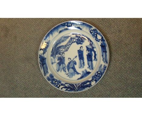An 18th century blue and white dish painted with four lady musicians playing within a fenced garden under a maple tree, the r
