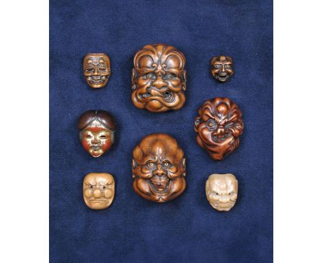 A wooden netsuke mask, possibly of Kokushiki, the man grimacing in a determined way, the veins on his forehead pronounced as 