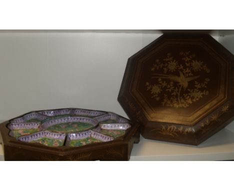 A lacquer cased enamel supper set, the octagonal lift off lid gilt with a bird in a flowering tree, the interior with a flowe