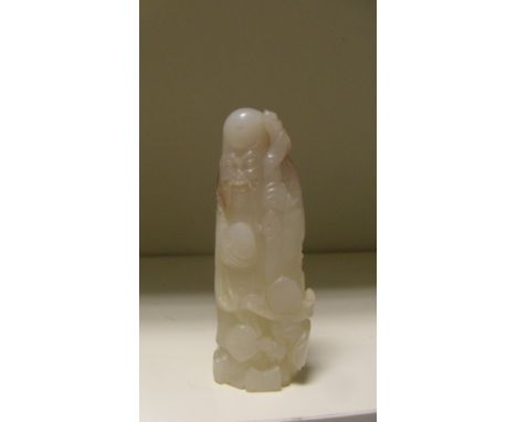 An 18th century white jade figure of Shoulao, he stands holding his staff in his left hand and a peach in his right, further 